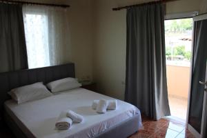 1 dormitorio con 1 cama con toallas en Margarita - Entire house with 4 bedrooms and free parking, en Gjirokastra