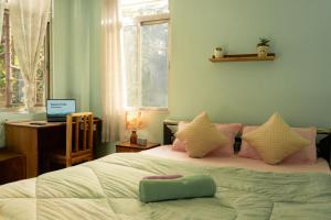 a bedroom with a bed and a desk with a laptop at Basant Hritu Homestay in Kalimpong