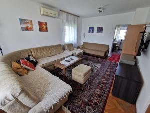 een woonkamer met een bank en een tafel bij Apartments Domaćinstvo Nikolić in Valjevo