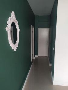 a green room with a mirror and a hallway at Homing Plateau - Apartment in the city of Praia in Praia