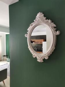 espejo blanco en una pared verde en una habitación en Homing Plateau - Apartment in the city of Praia en Praia