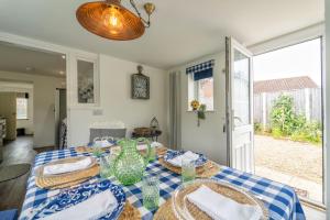 a dining room with a table with a blue and white table cloth at Briar Lea in Aldeburgh