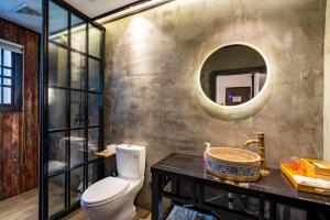 a bathroom with a toilet and a mirror at Tianyiju Inn - Suzhou Tongli Ancient Town in Suzhou