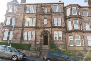 ein altes Backsteingebäude mit davor geparkt in der Unterkunft Centrally located 1 bed flat with furnishings & white goods. in Gourock