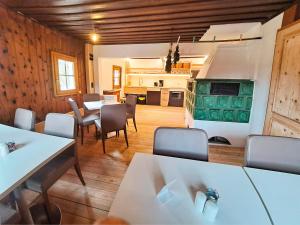 a dining room with tables and chairs and a kitchen at Ferienhof Holzmeister in Sankt Jakob in Haus