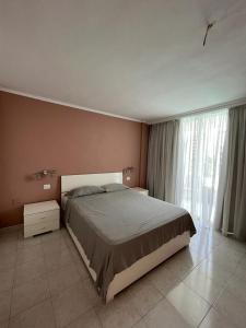 a bedroom with a bed and a large window at Cozy Apartment near the beach in Playa de las Americas