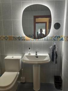 a bathroom with a toilet and a sink and a mirror at Casa Balcones - Benalmadena Pueblo in Benalmádena