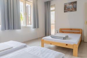 sypialnia z dwoma łóżkami i oknem w obiekcie Barát Vendégház - Cosy Guesthouse - Teljes ház privát udvarral - 4 szoba, 2 fürdő w Segedynie
