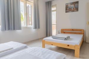 1 dormitorio con 2 camas y ventana en Barát Vendégház - Cosy Guesthouse - Teljes ház privát udvarral - 4 szoba, 2 fürdő, en Szeged