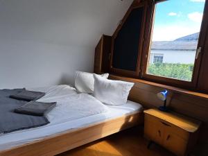a bed in a room with a window at Haus mit idyllischem Seeblick in Schalkenmehren