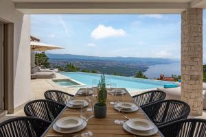 een eettafel met stoelen en uitzicht op een zwembad bij Luxury Villa Dana Indoor Pool and Sauna - Happy Rentals in Ičići