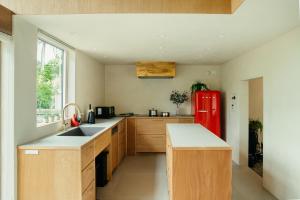 eine Küche mit einem roten Kühlschrank und Holzschränken in der Unterkunft Hutte Gartenland -KAIZUKA- ヒュッテ ガーテンラント カイヅカ in Karuizawa
