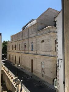 ein großes Steingebäude an der Straßenseite in der Unterkunft La Maison Racine 4 - Cocon en plein centre ville in Avignon