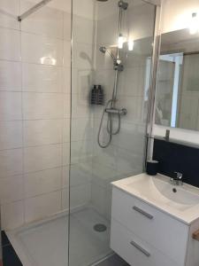 ein weißes Bad mit einer Dusche und einem Waschbecken in der Unterkunft La Maison Racine 4 - Cocon en plein centre ville in Avignon