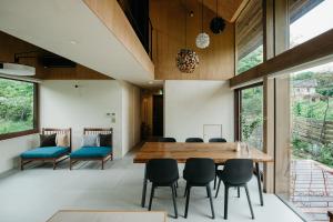輕井澤的住宿－Hutte Gartenland -KAIZUKA- ヒュッテ ガーテンラント カイヅカ，一间带木桌和椅子的用餐室