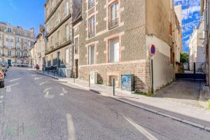 una calle vacía con un edificio de ladrillo y un semáforo en Charmant et lumineux T2 centre ville au calme en Nantes