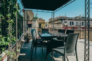 a patio with a table and chairs on a balcony at La bella vita luxury apartament and travel solution in Naples