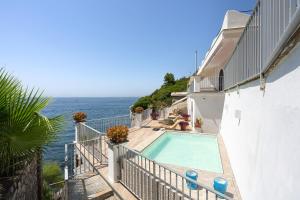 a swimming pool on the side of a building next to the ocean at Villa Lia in Massa Lubrense