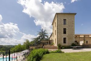 a large brick building with a pool in front of it at Château de Sanse in Sainte-Radegonde