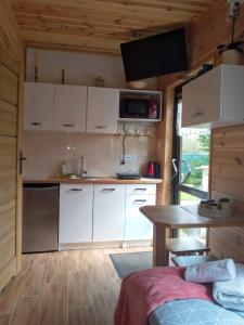 a kitchen with white cabinets and a table in a room at Agroturystyka Kasprzykówka 