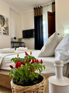 - un panier en osier avec des fleurs rouges sur une table dans la chambre dans l'établissement Bed and Breakfast Onde Beach, à Su Forti