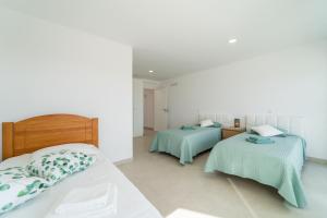 - 2 lits dans une chambre aux murs blancs dans l'établissement Vale Terra Mar, à Aljezur