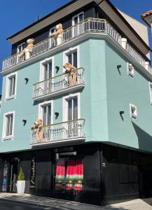 a blue building with a teddy bear on a balcony at Hotel Muchacho in Macedo de Cavaleiros