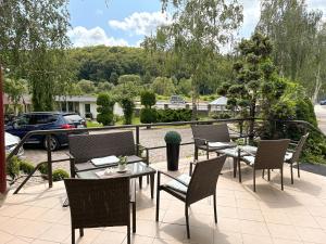 a patio with tables and chairs and a view of a car at Koral Hotel in Verkhniy Koropets