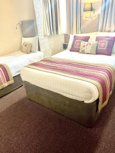 a hotel room with two beds and a window at Clifton Court Hotel in Blackpool