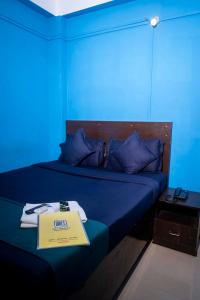 ein blaues Zimmer mit einem Bett und einem Schild darauf in der Unterkunft Shree Krishna GH in Guwahati