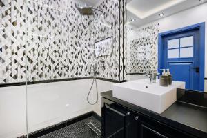 Łazienka z białą umywalką i niebieskimi drzwiami w obiekcie About Art Apartments - Sikorskiego we Wrocławiu +9 zdjęć