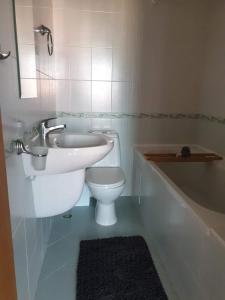 een badkamer met een wastafel, een toilet en een bad bij Victoria Villa, 13 Merlot street, The Vineyards resort, Aheloy, Pomorie. in Boergas