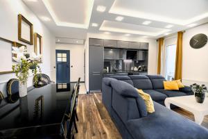 salon z niebieskimi kanapami i kuchnią w obiekcie About Art Apartments - Sikorskiego we Wrocławiu