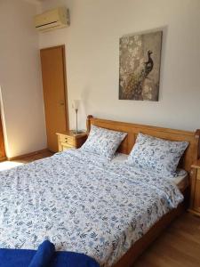 a bedroom with a bed with a blue and white comforter at Victoria Villa, 13 Merlot street, The Vineyards resort, Aheloy, Pomorie. in Burgas