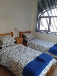 a bedroom with two beds with blue sheets and a window at Victoria Villa, 13 Merlot street, The Vineyards resort, Aheloy, Pomorie. in Burgas City
