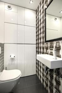 łazienka z toaletą, umywalką i lustrem w obiekcie About Art Apartments - Sikorskiego we Wrocławiu