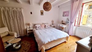 a bedroom with a white bed and a chair at La Garance Voyageuse in Boyne