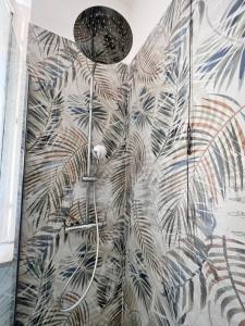 a shower in a bathroom with a mural of plants at Splendid Lake 3 in Desenzano del Garda