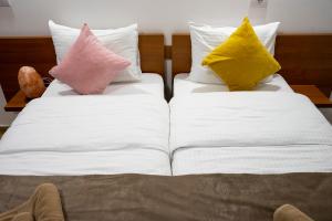 2 cuscini posti sopra un letto di Hotel Alexander a Sopot