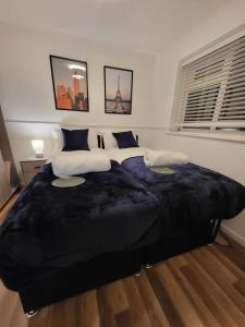 a large bed with a large black blanket in a bedroom at Lovely 2-Bed Apartment in Grays in South Ockendon
