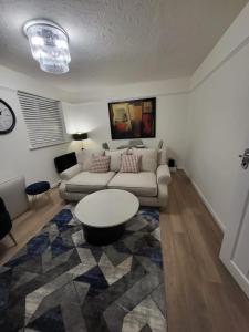 een woonkamer met een bank en een tafel bij Lovely 2-Bed Apartment in Grays in South Ockendon