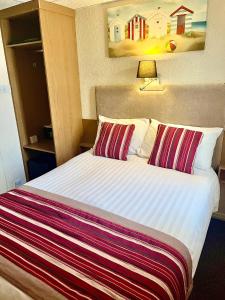 ein Hotelzimmer mit einem Bett mit zwei Kissen in der Unterkunft Clifton Court Hotel in Blackpool
