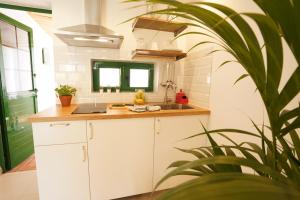 een keuken met witte kasten en een wastafel en een plant bij Maspalomas Suite by "The Stay Las Palmas" in Maspalomas