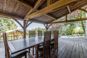 un tavolo e sedie in legno su una terrazza di legno di Vila avec, piscine, tennis. a Rivaux