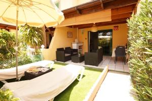 een patio met stoelen en een parasol bij Maspalomas Suite by "The Stay Las Palmas" in Maspalomas