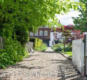 a driveway leading to a house with a fence at Clarendon Cottage in Enfield
