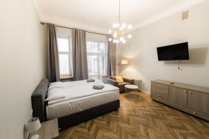 a bedroom with a bed and a flat screen tv at Apartments JustLvivIt at the Rynok Square in Lviv
