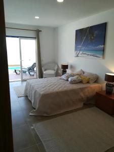 a bedroom with a bed with a view of the ocean at Pôr do Sol in Aljezur