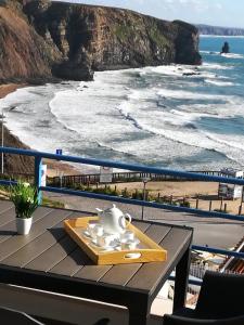 - une table sur un balcon avec vue sur la plage dans l'établissement Pôr do Sol, à Aljezur