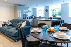 een woonkamer met een blauwe bank en een tafel bij Stylish & Contemporary 2-Bedroom House in Worksop